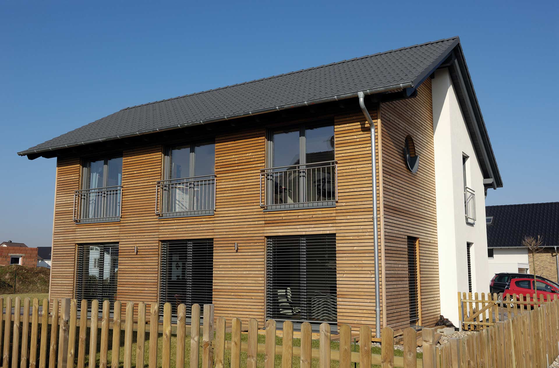 Ein modernes Einfamilienhaus mit einer Rhombusholzfassade