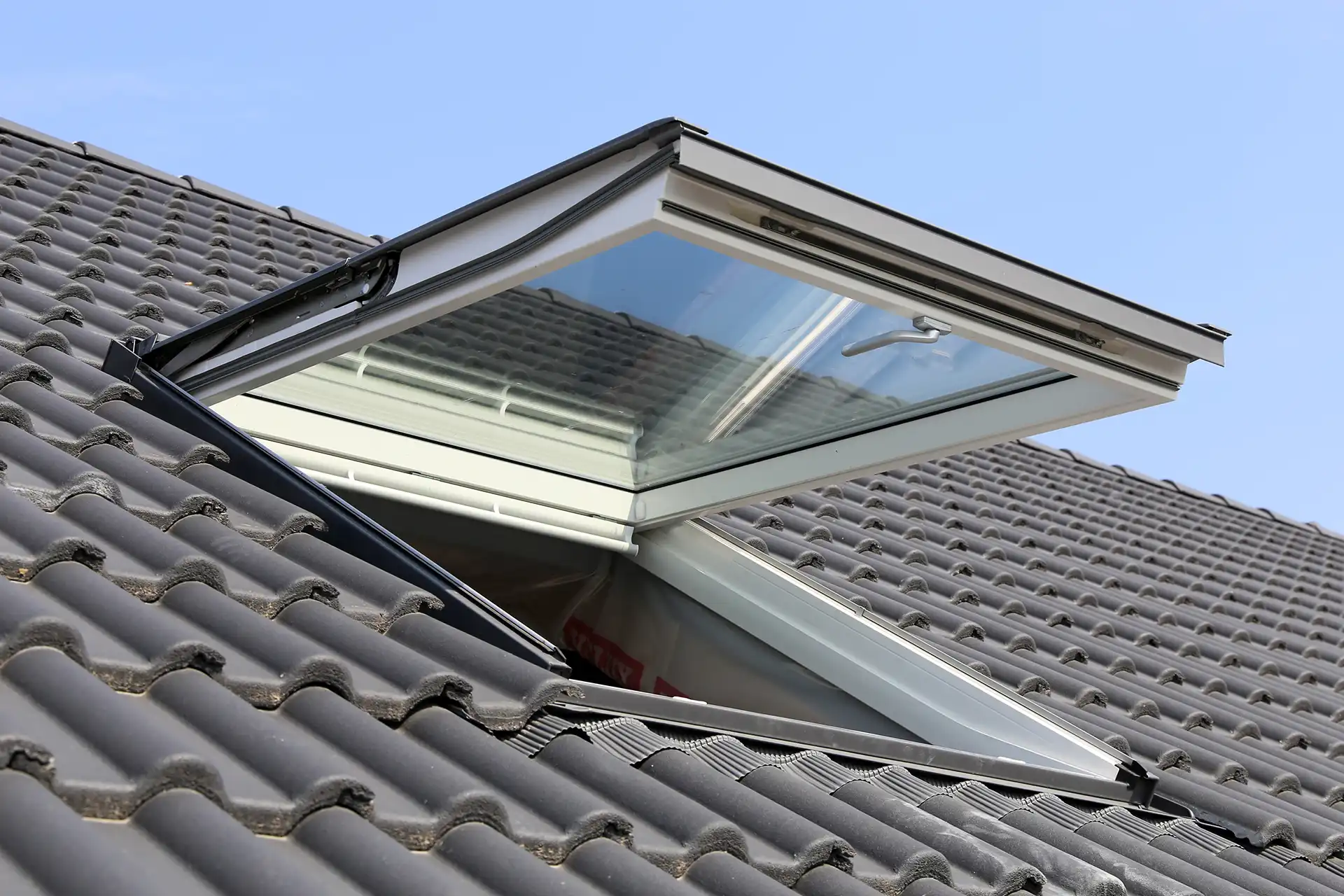 Ein geöffnetes Dachfenster in einem grauen Dach