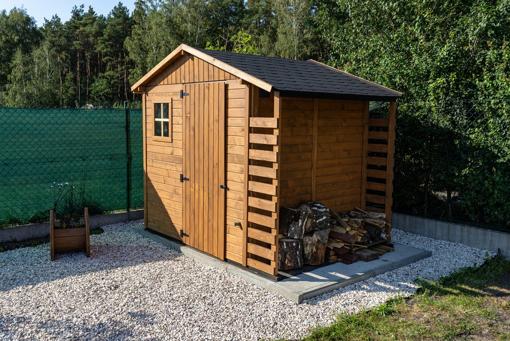 Ein braunes Gartenhaus aus Holz im Garten