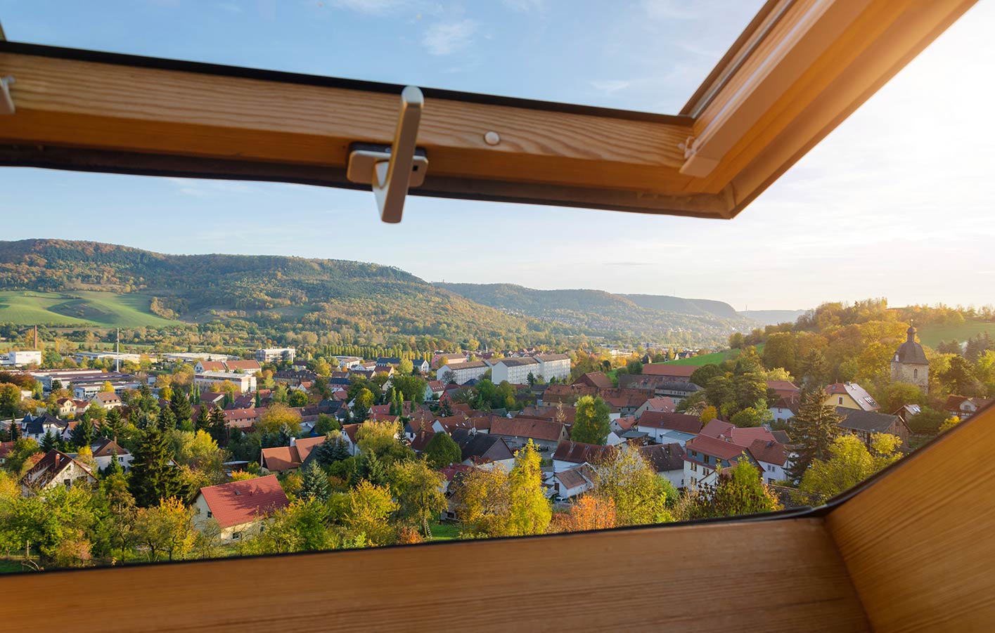 Blick nach draußen durch das geöffnete Holzdachfenster